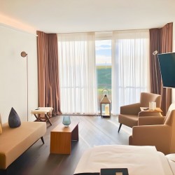 Apartment Juistblick 1 – Heller Wohnbereich mit Panoramafenstern und gemuetlicher Sitzecke fuer moebliertes Wohnen auf Zeit