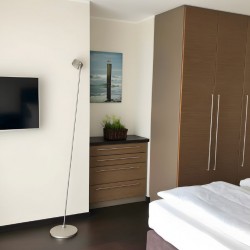 Apartment Morgensonne 4 – Helles Schlafzimmer mit Kleiderschrank und TV für komfortables Langzeitwohnen