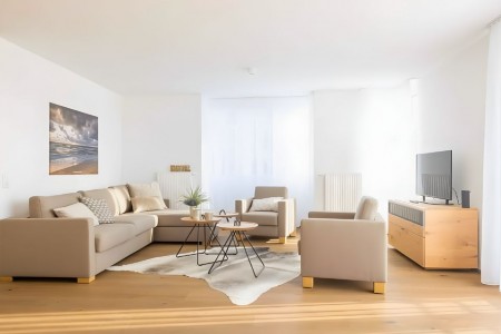Apartment Schwalbennest 1 OG – Helles Wohnzimmer mit komfortabler Sitzecke und TV