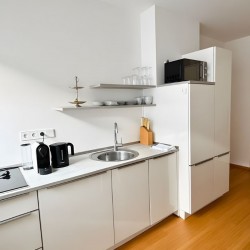 Einbaukueche im Apartment Bilk 1 – Moderne weisse Kuechenzeile mit Mikrowelle in Duesseldorf 1