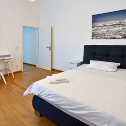 Helles Schlafzimmer im Apartment Hofgarten 0 – Komfortables Bett und Schreibtisch in Duesseldorf