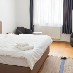 Modernes Schlafzimmer im Apartment Derendorf 2 – Komfortables Bett Sessel und Tageslicht in Duesseldorf 1