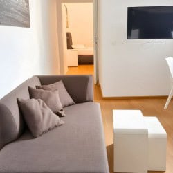 Wohnzimmer im Apartment Hofgarten 0 – Gemuetliches Sofa TV und moderner Essbereich in Duesseldorf